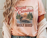 "Stupid Canadian Wolf Bird Heated Rivalry" design on a peach unisex t-shirt