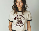 "Stay Salty Cowgirl" design on a natural ringer t-shirt with black contrast trim