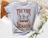 "Tis The Season Dancing Skeleton" design on a heather gray unisex t-shirt