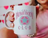 "The Homebody Club" design on a white ceramic coffee mug