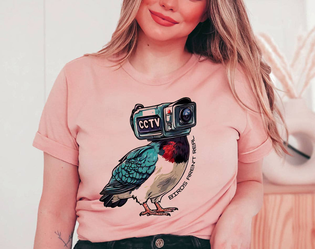 "Birds Aren't Real" design on a peach unisex t-shirt