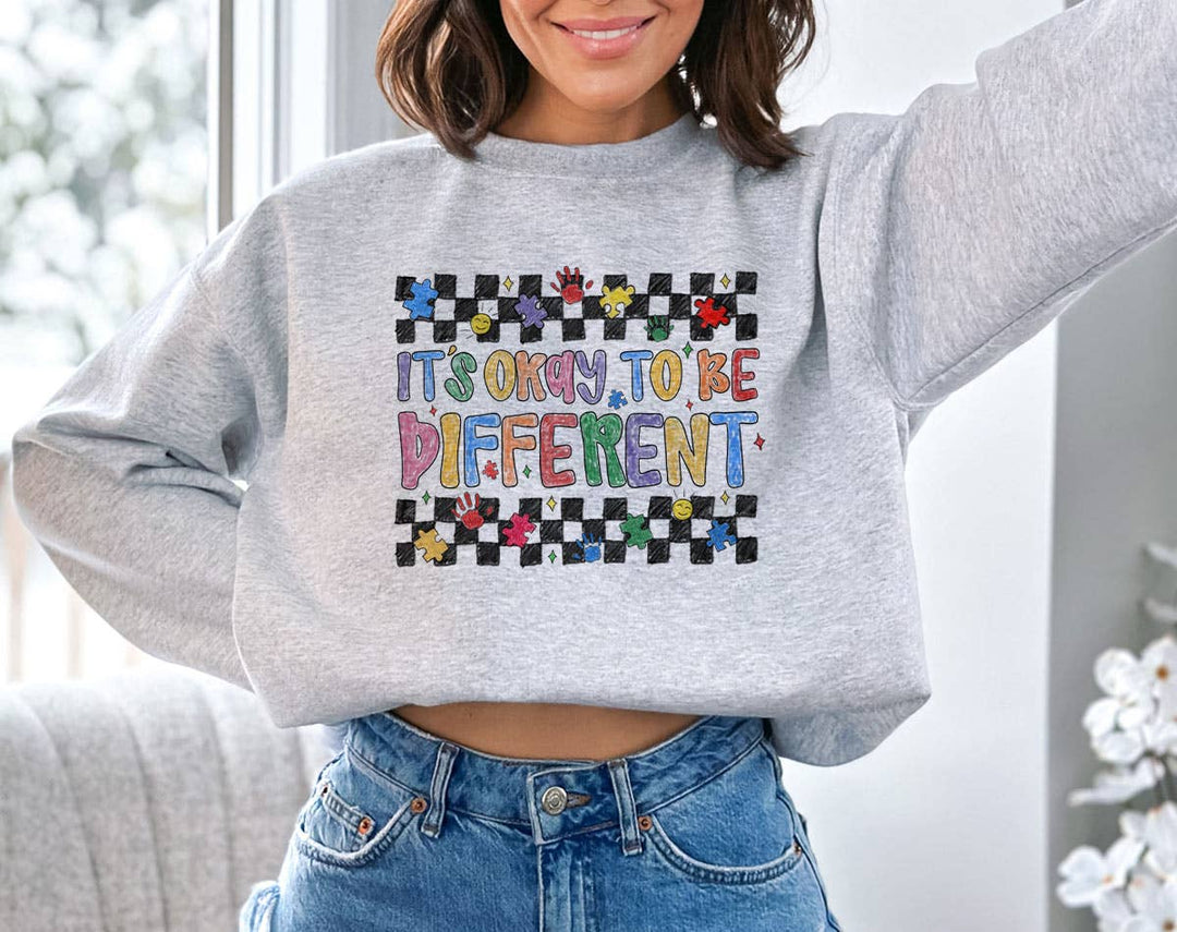 "It's Okay To be Different" design on an ash gray unisex crewneck sweatshirt
