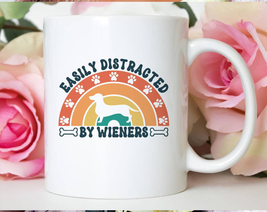 "Easily Distracted By Wieners" design on a white ceramic coffee mug