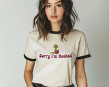 "Sorry I'm Booked" design on a natural ringer t-shirt with black contrast trim