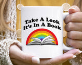 "Take A Look, It's In A Book" design on a white ceramic coffee mug