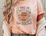 "I Take My Coffee On The Rocks" design on a peach unisex t-shirt
