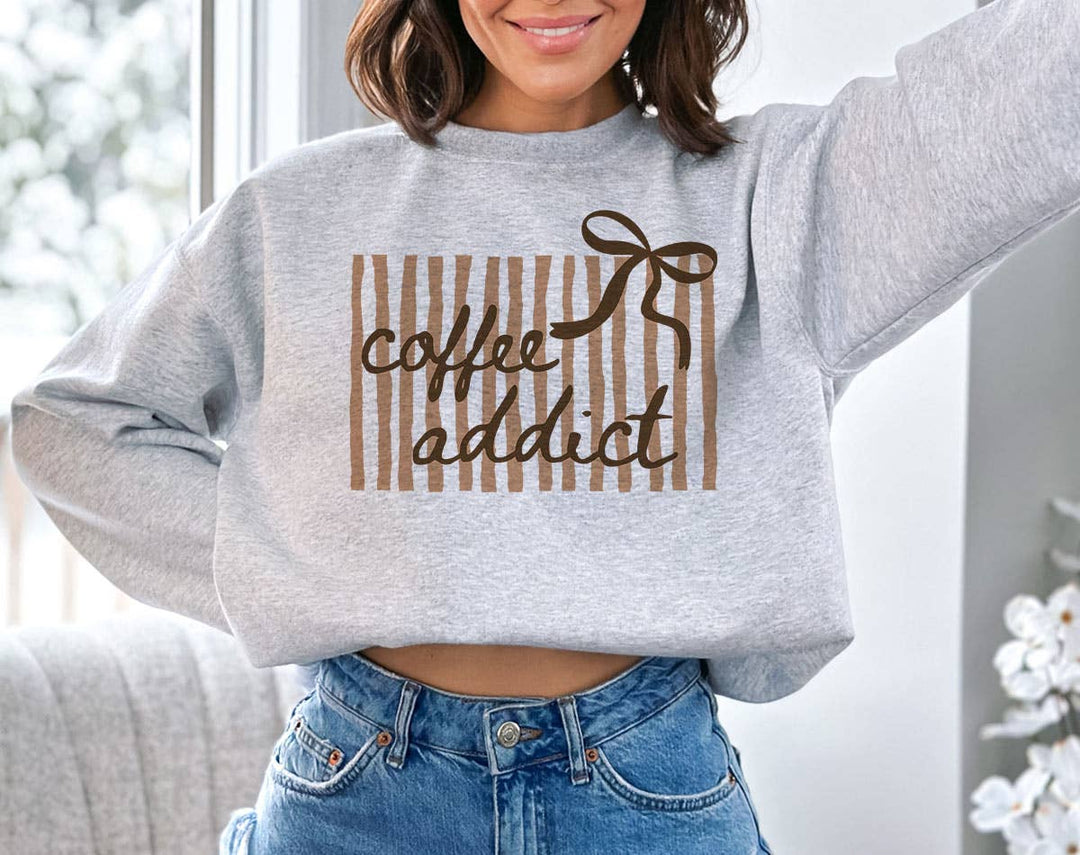 "Coffee Addict Striped Bow" design on an ash gray unisex crewneck sweatshirt