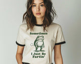 "Sometimes I Just Be Fartin' Frog" design on a natural ringer t-shirt with black contrast trim
