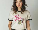 "Am I The Drama? Frog Meme" design on a natural ringer t-shirt with black contrast trim