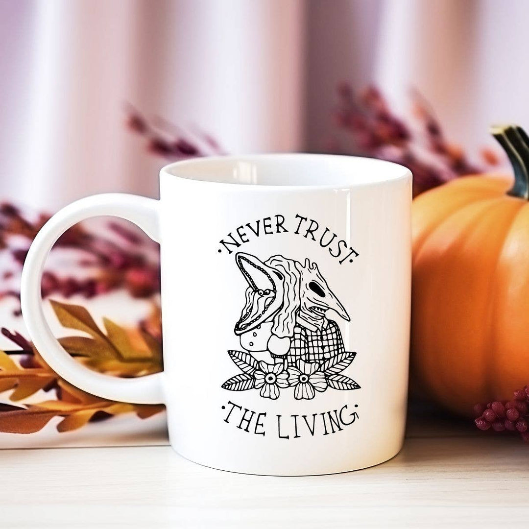 "Never Trust the Living" Halloween design on a white coffee mug