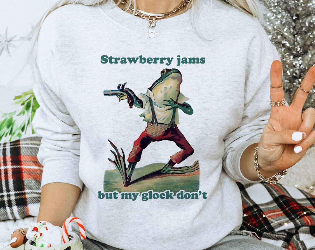 "Strawberry Jams, Glock Don't" design on an ash gray unisex crewneck sweatshirt