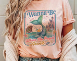 "I Wanna Be Where The People Aren't Mermaid" design on a peach unisex t-shirt