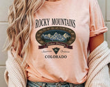 "Rocky Mountains Hiking" design on a peach unisex t-shirt