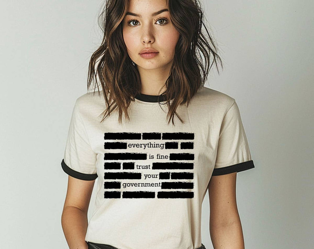 "Everything Is Fine Trust Your Government" design on a natural ringer t-shirt with black contrast trim