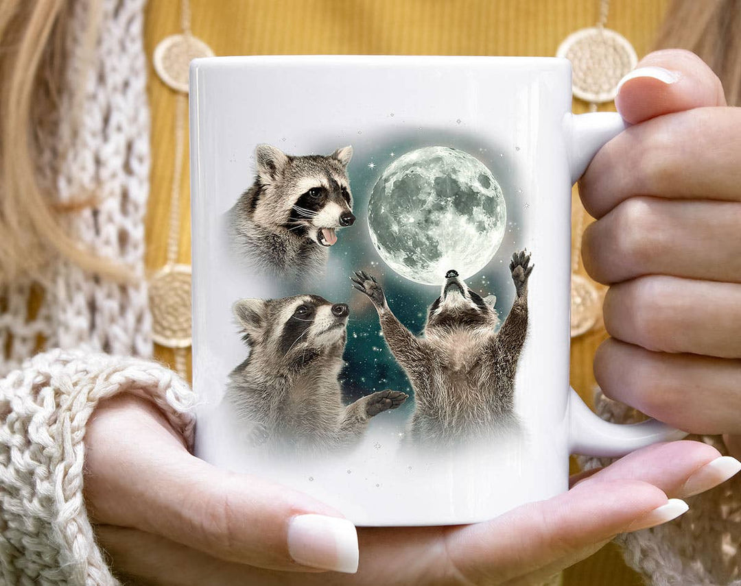 "3 Raccoons Howling" design on a white ceramic coffee mug