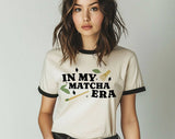 "In My Matcha Era" design on a natural ringer t-shirt with black contrast trim