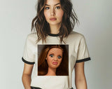 "Disgusted Doll Face Meme" design on a natural ringer t-shirt with black contrast trim
