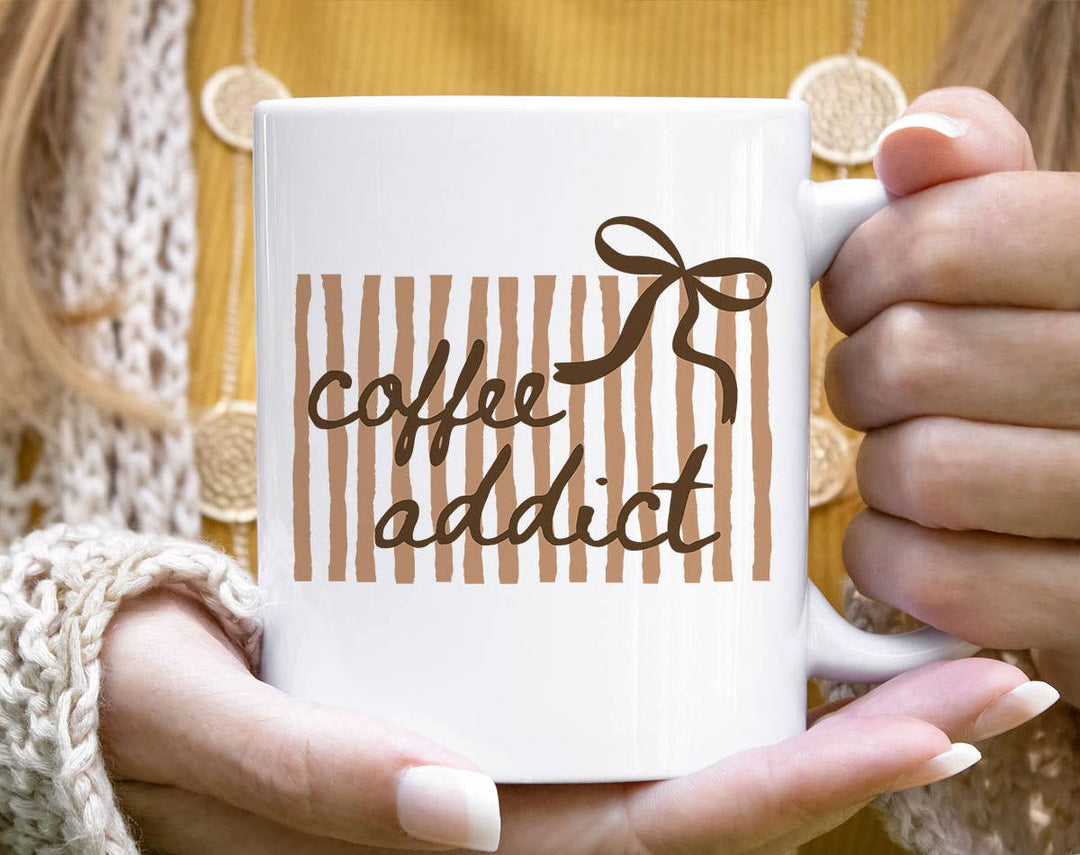 "Coffee Addict Striped Bow" design on a white ceramic coffee mug