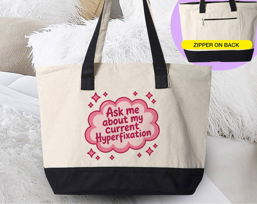 "Ask Me About My Current Hyperfixation ADHD" design on a natural canvas zippered tote bag