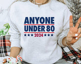 "Anyone Under 80" design on an ash gray unisex crewneck sweatshirt