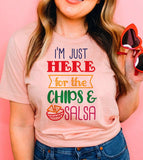 "I'm Just Here For The Chips" design on a peach unisex t-shirt