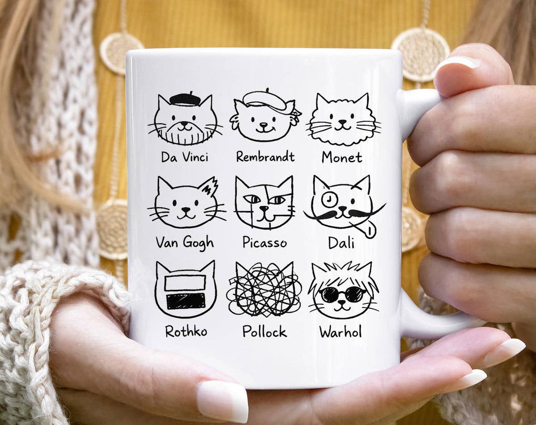 "Artistic Cat Painters Warhol Da Vinci Dali" design on a white ceramic coffee mug