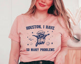 "Houston, I Have So Many Problems" design on a peach unisex t-shirt