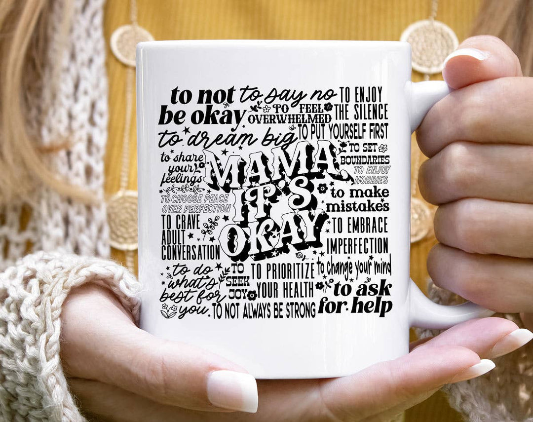"Mama, It's Okay" design on a white ceramic coffee mug