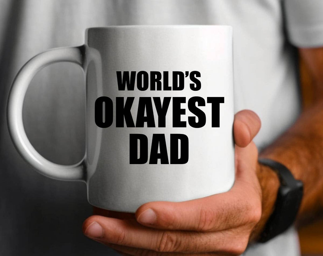 "World's Okayest Dad" design on a white ceramic coffee mug