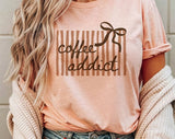 "Coffee Addict Striped Bow" design on a peach unisex t-shirt