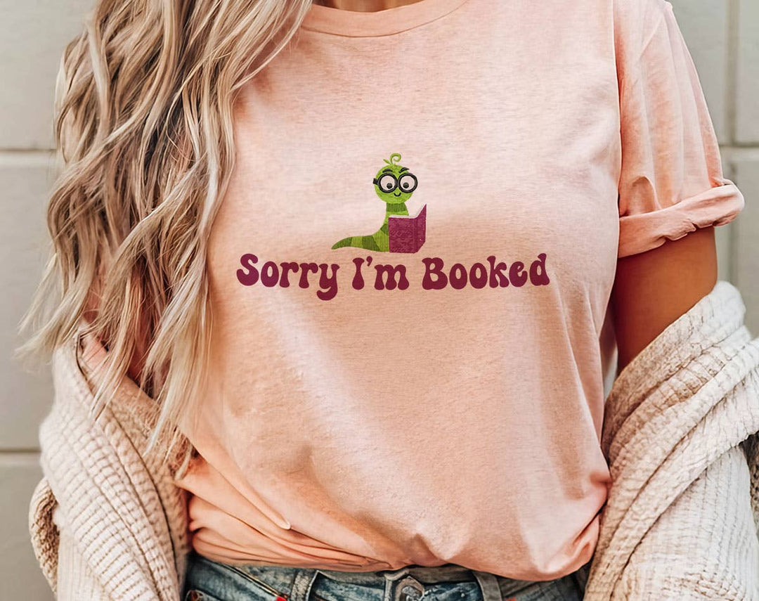 "Sorry I'm Booked" design on a peach unisex t-shirt