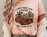 "I Know Your Lane Sucks Skeleton" design on a peach unisex t-shirt
