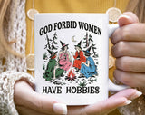 "God Forbid Women Have Hobbies" Halloween design on a white coffee mug