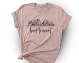 "Booktrovert Bookshelf" design on a peach unisex t-shirt