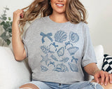 "Seashell Blue Beach Collage" design on a heather gray unisex t-shirt
