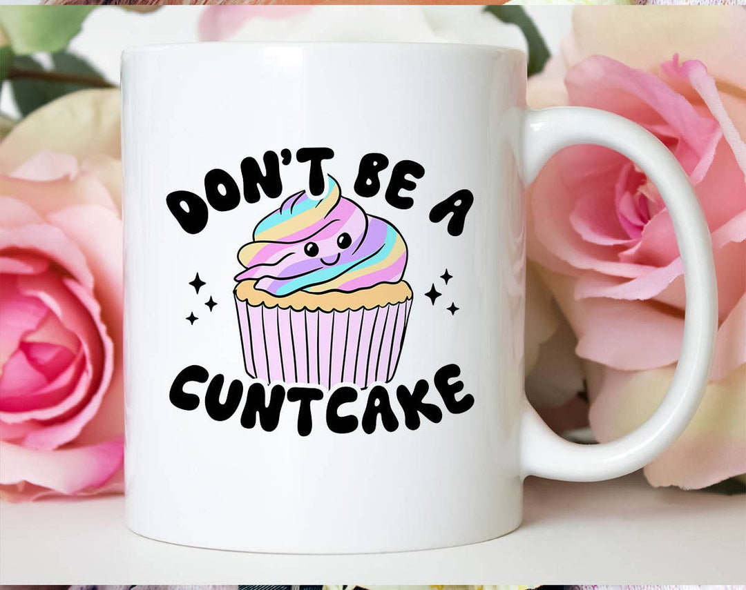 "Don't Be A Cuntcake" design on a white ceramic coffee mug