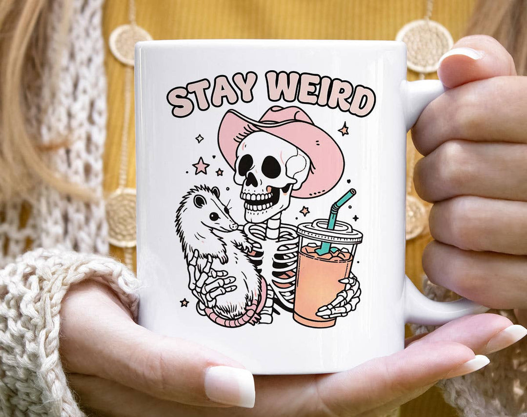 "Stay Weird" design on a white ceramic coffee mug