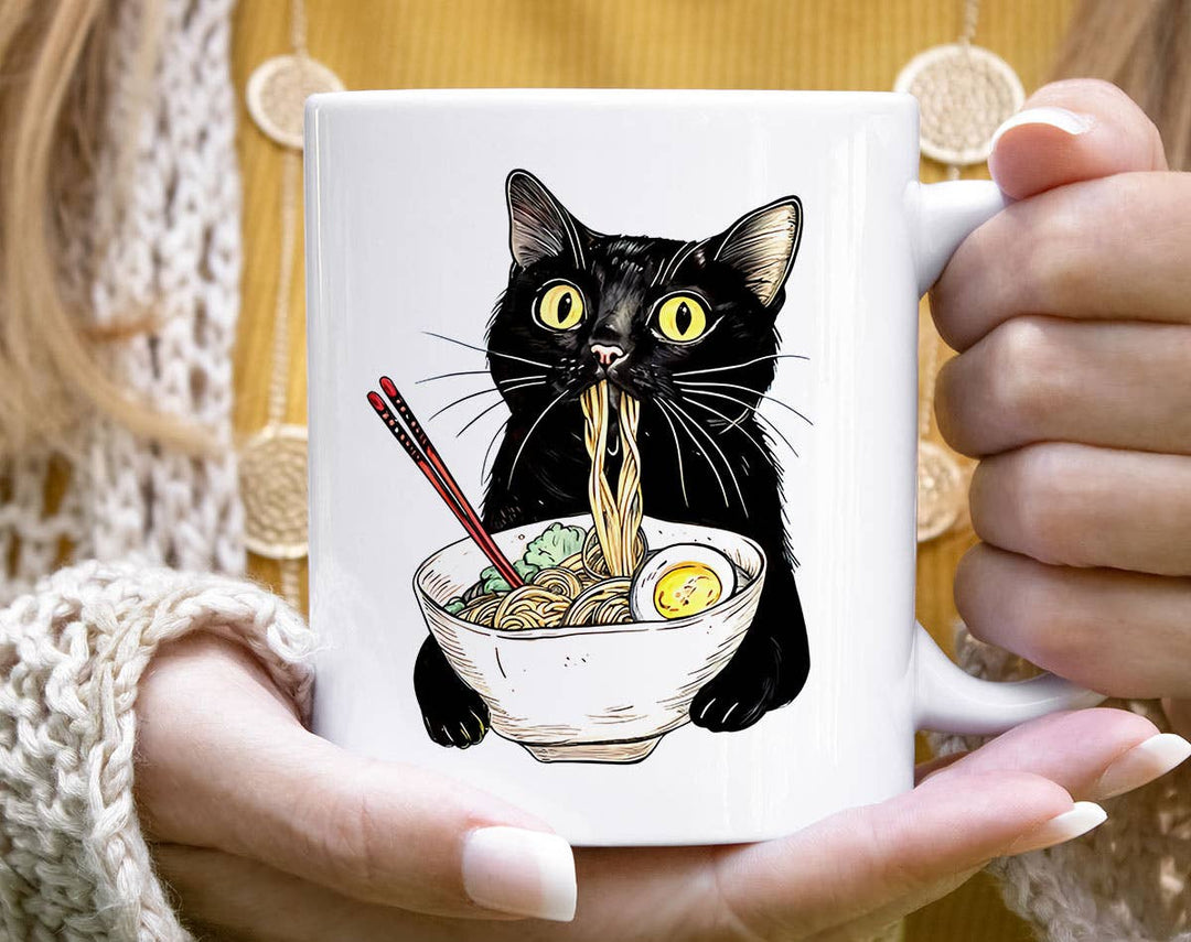 "Cat Eating Ramen" design on a white ceramic coffee mug