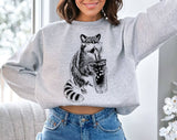 "Raccoon Drinking Iced Coffee" design on an ash gray unisex crewneck sweatshirt