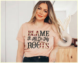 "Blame It All On My Roots" design on a white unisex t-shirt