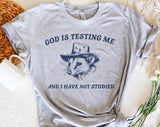 "God Is Testing Me Possum" design on a heather gray unisex t-shirt