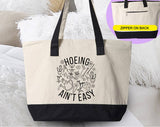 "Hoeing Ain't Easy" design on a natural canvas zippered tote bag