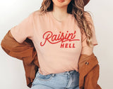 "Raisin' Hell" design on a peach unisex t-shirt