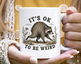 "It's Okay To Be Weird Jimothy" design on a white ceramic coffee mug