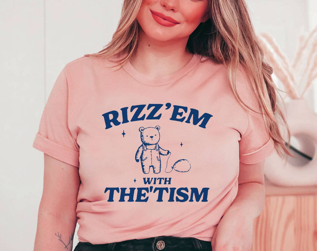 "Rizz 'Em With The 'Tism Bear" design on a peach unisex t-shirt