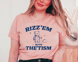 "Rizz 'Em With The 'Tism Bear" design on a peach unisex t-shirt