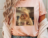 "Doll Face Meme Hot Mess Coffee" design on a peach unisex t-shirt