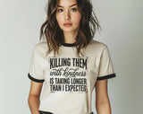 "Killing Them With Kindness" design on a natural ringer t-shirt with black contrast trim