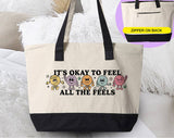 "It's Okay To Feel All The Feels" design on a natural canvas zippered tote bag