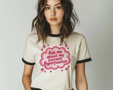"Ask Me About My Current Hyperfixation" design on a natural ringer t-shirt with black contrast trim